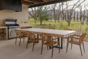 eine Küche mit Tisch, Stühlen und Herd in der Unterkunft Hotel Santolivo by Lumina in Parras de la Fuente
