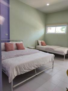 a bedroom with two beds and a window at Banyai Pool Villa Chiang Khan in Loei
