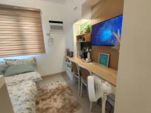 a bedroom with a desk and a bed in a room at Naomi's Green Haven in Dasmariñas