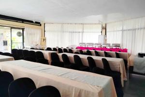 a room with rows of tables and chairs in it at Alta Cebu Resort Mactan powered by Cocotel in Mactan