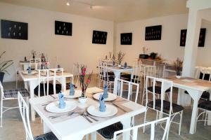 a dining room with white tables and white chairs at Alta Cebu Resort Mactan powered by Cocotel in Mactan
