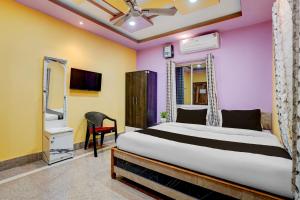 a bedroom with a bed and a chair in it at Hotel O Puri Seaview Formerly Sea Star in Puri