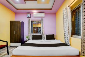 a bedroom with a bed and a purple and yellow wall at Hotel O Puri Seaview Formerly Sea Star in Puri +33 photos