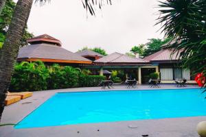 a large blue swimming pool in front of a house at Alta Cebu Resort Mactan powered by Cocotel in Mactan +40 photos