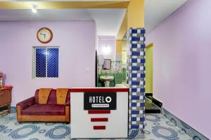 a lobby with a couch and a clock on a wall at Hotel O Puri Seaview Formerly Sea Star in Puri