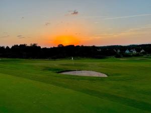 a sunset on a golf course with a hole at Ferienhaus Schieferland in Müllenbach