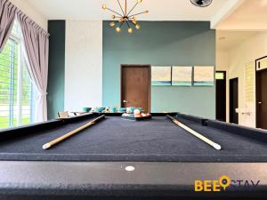 a pool table with cue sticks on top of it at Desaru Arcadia Double Storey House 11-16 Pax 5 Mins to Desaru Beach in Bandar Penawar