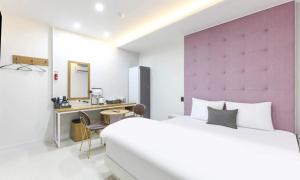 a bedroom with a large bed and a desk at Gimcheon Sweet Hotel in Kimch'ŏn