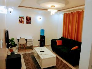 a living room with a couch and a table at Open Haven One Bedroom Apartments in Ongata Rongai 