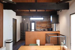 a kitchen with a wooden table in a room at Manabi-WAN Takayama in Takayama