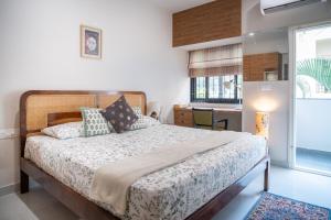 a bedroom with a large bed and a kitchen at Luho Aarambha in Bangalore