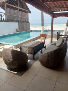 a swimming pool with two chairs and a table and a tablektop at Escape villa assouinde in Assinie