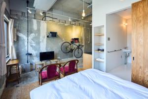 a bedroom with a bed and two chairs and a bike on the wall at ホテル こばやし in Kanoya