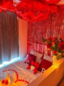 a bedroom with a bed with red decorations at Le Cocon de Rose & Achille in Boulogne-sur-Mer