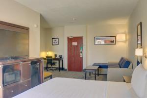 a hotel room with a bed and a living room at Quality Inn & Suites Roswell North in Roswell