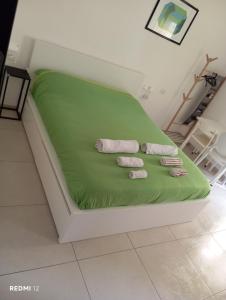 a bed with green sheets and two towels on it at Casa vacanze TRINISULA Sicily home in Scicli +46 photos