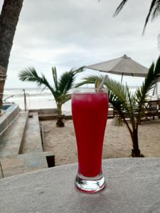 a drink in a glass sitting on a table on the beach at Escape villa assouinde in Assinie