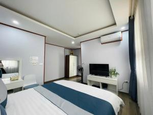 a hotel room with a bed and a television at Home Villa TP Giao Lưu in Hanoi