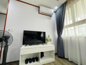 a living room with a tv on a white cabinet at Home Villa TP Giao Lưu in Hanoi