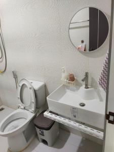a bathroom with a toilet and a sink and a mirror at Banyai Pool Villa Chiang Khan in Loei +37 photos