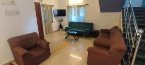 a living room with two chairs and a couch at 4 Bedroom House, Morjim Main Road in Morjim