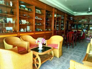 a restaurant with chairs and a table with a vase of flowers at Thepparat Lodge Krabi in Krabi