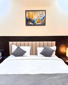 a bedroom with a large bed with white sheets and pillows at Barsana Suites in Vrindāvan