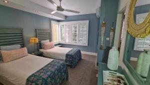 a bedroom with two beds and a ceiling fan at Luxury 3BR Direct Beach Access & Pool in Cap Malheureux +4 photos