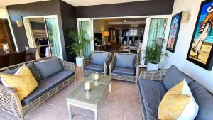 a living room with couches and chairs and a table at Luxury 3BR Direct Beach Access & Pool in Cap Malheureux