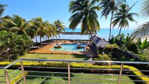 a resort with a pool and palm trees and the ocean at Luxury 3BR Direct Beach Access & Pool in Cap Malheureux