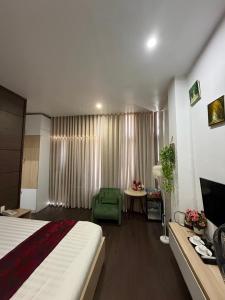 a hotel room with a bed and a chair and a television at Phi Long Hotel in Tuy Hoa