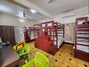 a room with bunk beds and a table and chairs at Lukochurri in Shānti Niketan