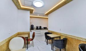 a room with chairs and a table and a kitchen at Gimcheon Sweet Hotel in Kimch'ŏn