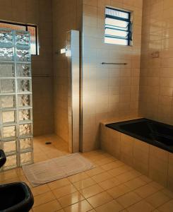 a bathroom with a shower and a bath tub at Pousada Pico do Papagaio in Aiuruoca +19 photos