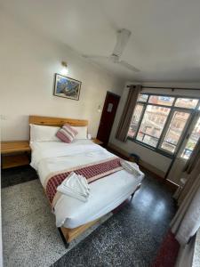 a bedroom with a large bed and a large window at Pacific Guest House in Kathmandu