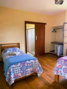 a bedroom with two beds and a sliding door at Pousada Pico do Papagaio in Aiuruoca