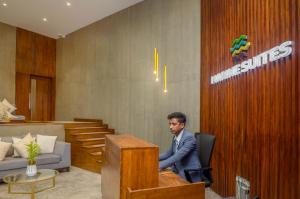 a man sitting in a chair at a desk at Marine Suites in Colombo