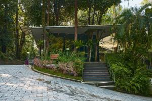 a building with a staircase in a park with trees at Siloso Beach Resort - Sentosa in Singapore