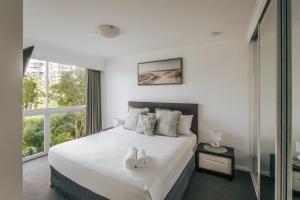 a bedroom with a large bed with two white shoes on it at The Crest Apartments - Main Beach in Gold Coast +52 photos