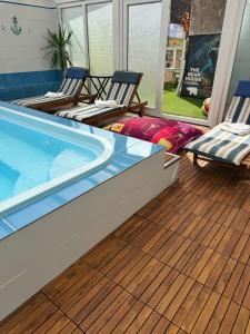 ein Swimmingpool auf einer Terrasse mit zwei Liegestühlen in der Unterkunft Hotel Gâlma in Moroeni
