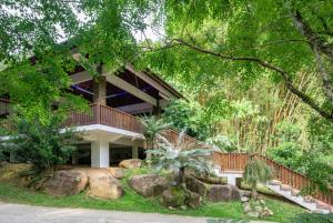 a house with a wooden staircase in a garden at Bidaisari Resort in Kampong Sum Sum