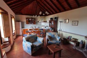 een woonkamer met 2 stoelen en een keuken bij Casa Rural Hermana "by henrypole home" in Breña