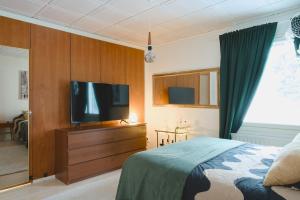 a bedroom with a bed and a flat screen tv at Villa Rimppari täydellinen porukalle 9 hlö puusauna nuotiopaikka ja parkki in Oulu