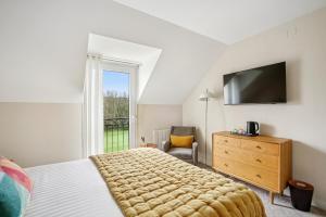a bedroom with a bed and a television and a chair at MH Hôtel & Spa Arradon - Golfe du Morbihan in Arradon +61 photos