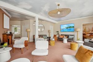 a living room with white chairs and a couch at MH Hôtel & Spa Arradon - Golfe du Morbihan in Arradon