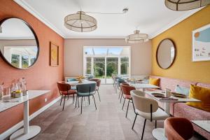 a restaurant with tables and chairs and windows at MH Hôtel & Spa Arradon - Golfe du Morbihan in Arradon