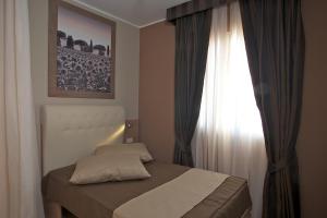 a small bedroom with a bed and a window at Hotel C'era Una Volta in Castiglione della Pescaia