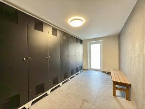 a locker room with a wooden bench in it at Apartmán Plešivec in Merklín