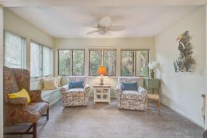 a living room with two chairs and a ceiling fan at West Beach Oceanwoods Cottage 442 in Kiawah Island