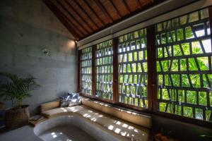 a room with a large tub in a room with windows at Sejati Boutique Hotel Uluwatu in Uluwatu +57 photos